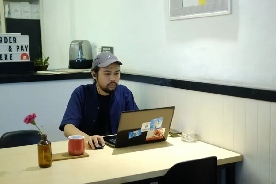 Seseorang bekerja dengan laptop dari kafe