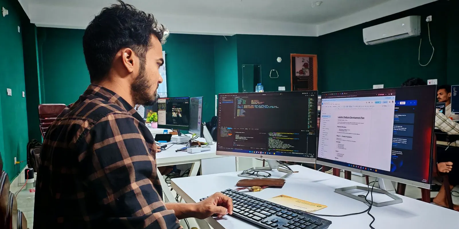 Programmer kerja di depan dua monitor