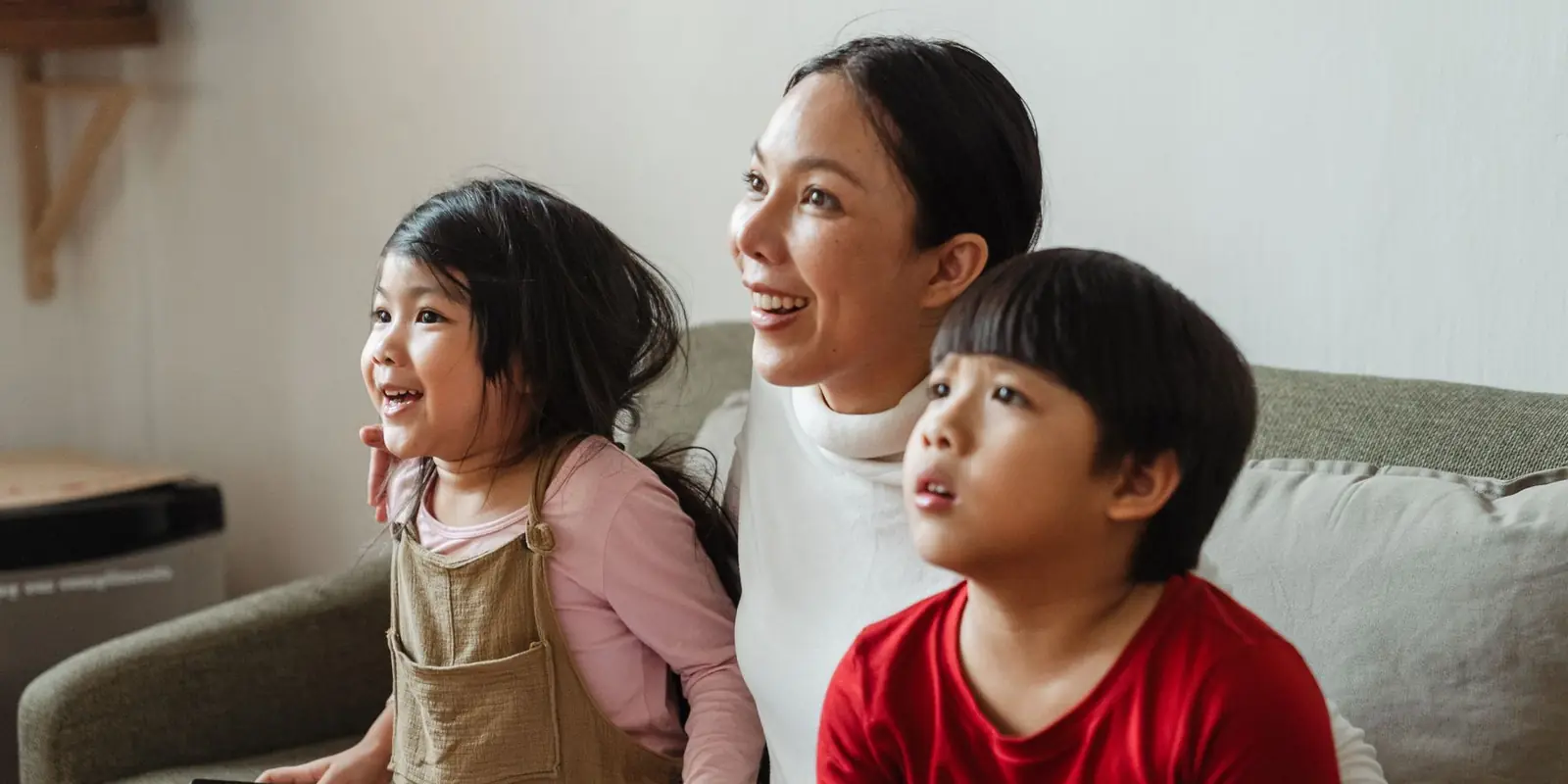 Ibu dan dua anak nonton film bareng di sofa